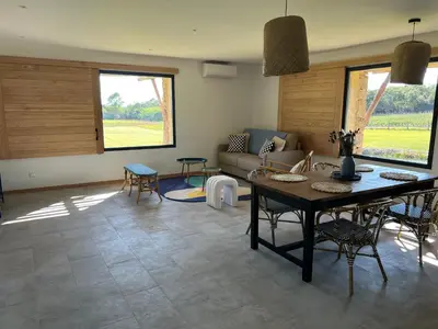 a living room with a table and a couch at Domaine Pozzo di Mastri hôtel & spa in Figari