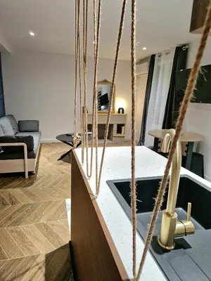 a living room with a kitchen with ropes at Charmant Appartement Centre-Ville d'Ajaccio in Ajaccio