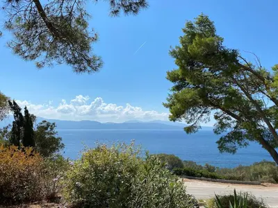 a view of the ocean from behind some trees at Villa panoramic - Dream and Suite Lodge in Vico