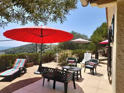 a red umbrella on a patio with chairs and tables at Villa panoramic - Dream and Suite Lodge in Vico