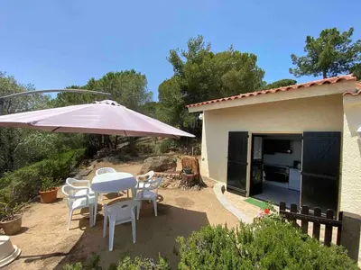 a patio with an umbrella and a table and chairs at Sagone villa sea view in Vico