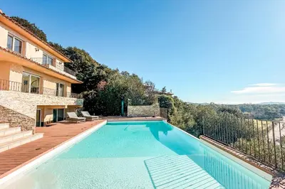 a swimming pool in front of a house with a building at Villa Golfo Di Sogno in Porto-Vecchio