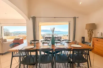 a dining room with a large table and chairs at Villa Golfo Di Sogno in Porto-Vecchio