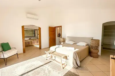 a bedroom with a bed and a couch and a chair at Villa Golfo Di Sogno in Porto-Vecchio