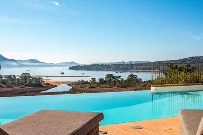 a swimming pool with a view of a body of water at Villa Golfo Di Sogno in Porto-Vecchio