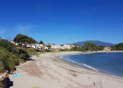 a beach with people laying on the sand and the water at marina di bravone - corse - linguizzetta in Linguizzetta