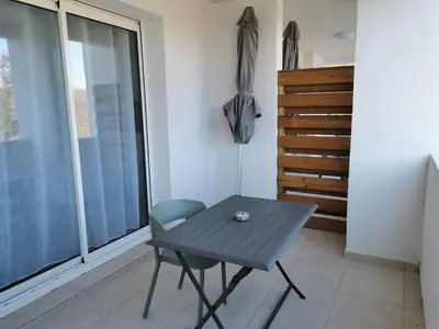 a table and a chair in a room with a window at marina di bravone - corse - linguizzetta in Linguizzetta