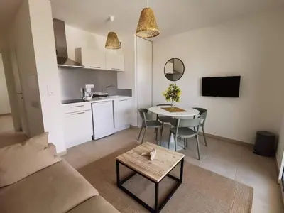 a living room with a couch and a table and a kitchen at marina di bravone - corse - linguizzetta in Linguizzetta
