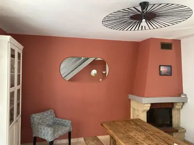 a dining room with a table and a fan at Maison bord de mer en Corse in Borgo