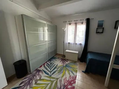 a bedroom with a sliding glass door and a floor at Maison bord de mer en Corse in Borgo