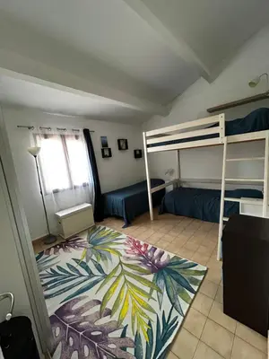 a bedroom with two bunk beds and a rug at Maison bord de mer en Corse in Borgo