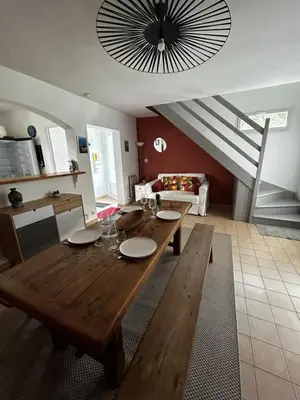 a living room with a wooden table and a staircase at Maison bord de mer en Corse in Borgo