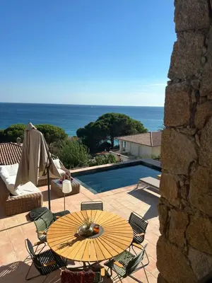 a patio with a table and chairs and a pool at Casa Raphael in Ajaccio