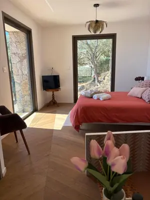 a bedroom with a red bed and a large window at Casa Raphael in Ajaccio