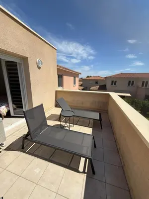 a patio with a chair and a table on a balcony at Villa désirée à Santa Maria Poggio in Santa-Maria-Poggio