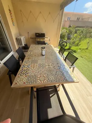 a table on a balcony with a table and chairs at Villa désirée à Santa Maria Poggio in Santa-Maria-Poggio