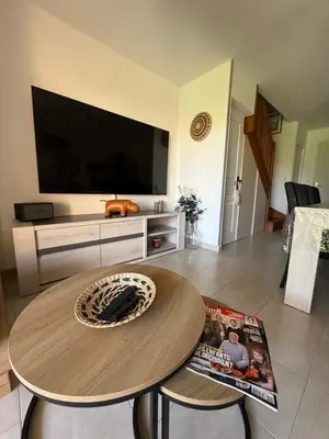 a living room with a table and a tv at Villa désirée à Santa Maria Poggio in Santa-Maria-Poggio
