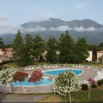 a view of a swimming pool with chairs and trees at Villa désirée à Santa Maria Poggio in Santa-Maria-Poggio
