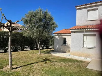 a yard next to a house with a tree at Casabella 3 chambres in Cervione