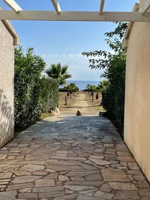 a stone pathway leading to a beach with the ocean at Casabella 3 chambres in Cervione