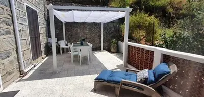 a patio with a white canopy and a table and chairs at Grande Maison de Village in Sollacaro