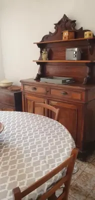 a wooden dresser in a room with a table at Grande Maison de Village in Sollacaro