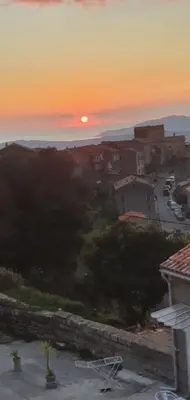 a sunset over a city with a street and buildings at Grande Maison de Village in Sollacaro