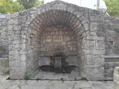 an old stone archway with a clock on it at Grande Maison de Village in Sollacaro