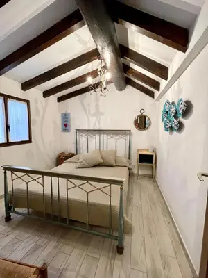 a bedroom with a bed in a room with wooden ceilings at Piana in Porto-Vecchio