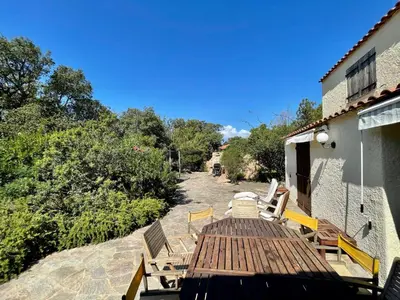 a wooden deck with chairs on the side of a house at Piana in Porto-Vecchio