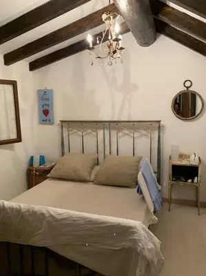 a bedroom with a large bed with a chandelier at Piana in Porto-Vecchio