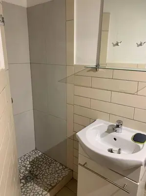 a white bathroom with a sink and a shower at Piana in Porto-Vecchio