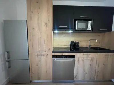 a kitchen with a refrigerator and a sink and a microwave at Mini villa avec jardin Cala Rossa - Porto Vecchio in Lecci