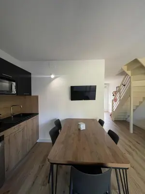 a kitchen and dining room with a wooden table at Mini villa avec jardin Cala Rossa - Porto Vecchio in Lecci
