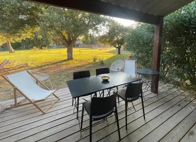 a black table and chairs on a wooden deck at Mini villa avec jardin Cala Rossa - Porto Vecchio in Lecci