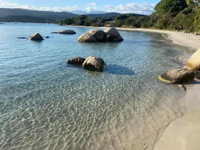 a group of rocks in the water on a beach at Mini villa avec jardin Cala Rossa - Porto Vecchio in Lecci