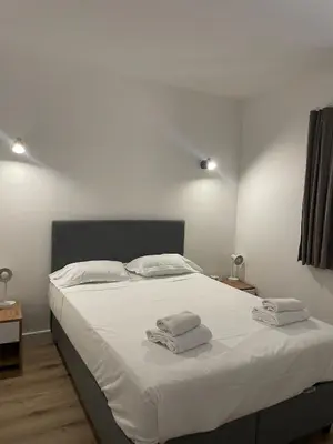 a bedroom with a white bed with towels on it at Mini villa avec jardin Cala Rossa - Porto Vecchio in Lecci