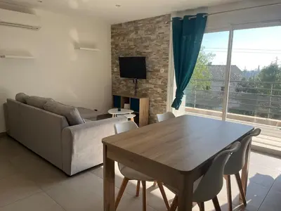 a living room with a table and a couch at Appartement proche de la plage in Santa-Lucia-di-Moriani