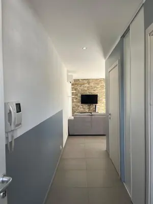 a hallway leading to a living room with a couch at Appartement proche de la plage in Santa-Lucia-di-Moriani