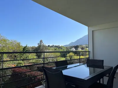 a balcony with a table and chairs and a view at Appartement proche de la plage in Santa-Lucia-di-Moriani