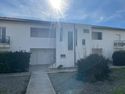 a white building with the sun shining on it at Appartement proche de la plage in Santa-Lucia-di-Moriani