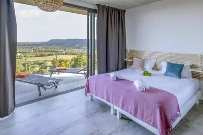 a bedroom with a large bed and a balcony at family villa, beautiful open sea view & scrubland in Conca