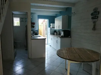 a kitchen with blue walls and a table in it at Maison bord de mer climatisée en Corse in Poggio-Mezzana