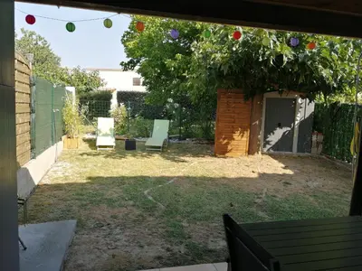 a yard with two chairs and a tree with apples at Maison bord de mer climatisée en Corse in Poggio-Mezzana