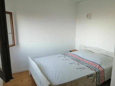 a bed in a room with white walls at Maison bord de mer climatisée en Corse in Poggio-Mezzana