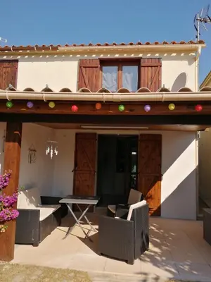 a patio with chairs and a table on a house at Maison bord de mer climatisée en Corse in Poggio-Mezzana