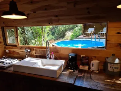a kitchen with a sink and a swimming pool at Cabane avec Piscine in Sartène
