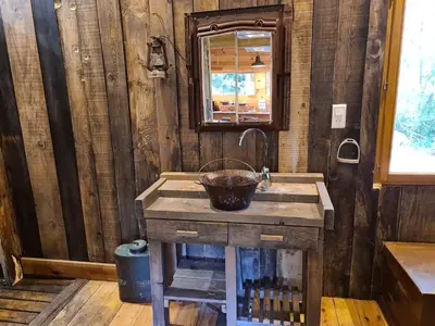 a wooden bathroom with a sink and a mirror at Cabane avec Piscine in Sartène