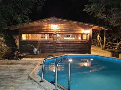 a swimming pool in front of a house at night at Cabane avec Piscine in Sartène