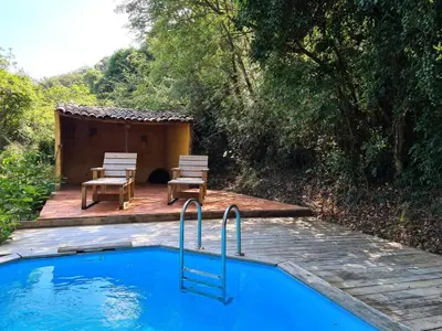 a swimming pool with two chairs and a hut at Cabane avec Piscine in Sartène